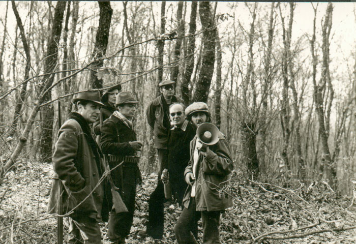 Περιγραφ: Ο Θδωρος Αγγελπουλος με συνεργτες του κατ τη διρκεια των γυρισμτων της ταινας «Οι κυνηγο», 1977